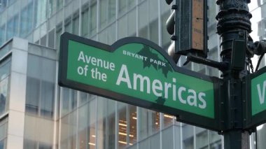 New York City kavşağı, sokak kavşağı yeşil yol tabelası. 6. Cadde, Amerika Bulvarı köşesi, Midtown İş Bölgesi, ABD. Yükselen gökdelen mimarisi, Bryant parkı metin yol işareti