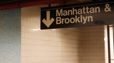 New York metro istasyonu içi, Manhattan mesaj tabelası. Yeraltı metropolü. Birleşik Devletler metro nakliye navigasyonu. Bilgi levhası kamu yolcu tren yolu. Şehir merkezi ve Brooklyn yönü