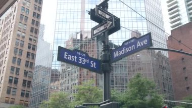 New York City kavşağı, Manhattan köşesi, Madison Bulvarı, sokak kavşağı tabelası. Midtown merkez bölgesi mimarisi, Birleşik Devletler. Tek yönlü ok işareti, gökdelenler. Düşük açı.