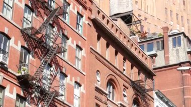 New York City Manhattan mimarisi. Şehir dışındaki konutlar. ABD 'de gayrimenkul. Kırmızı tuğla cephe. Yangın çıkışı, acil merdiven çıkışı. Çatıdaki su kulesi, çatıdaki tank..