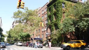 New York City, ABD, 6 Eylül 2023 Manhattan şehir merkezi Irving sokak köşesi, kavşak, Gramercy, ABD. İnsanlar yayalar. Sarı taksi. Sarmaşık yapraklarıyla kaplı kırmızı tuğladan ev