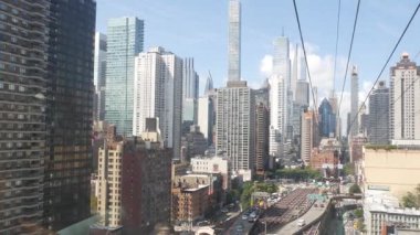New York, ABD - 12 Eylül 2023: Manhattan Midtown sokaklarına giden Roosevelt Adası tramvayı. Amerikan tramvayı, Queensboro Köprüsü. Kentsel toplu taşıma, ABD. Mimari şehir manzarası inşa ediliyor