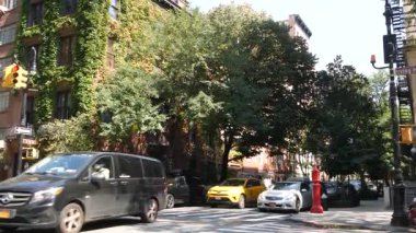New York City, ABD, 6 Eylül 2023 Manhattan şehir merkezi Irving sokak köşesi, kavşak, Gramercy, ABD. İnsanlar yayalar. Sarı taksi. Sarmaşık yapraklarıyla kaplı kırmızı tuğladan ev