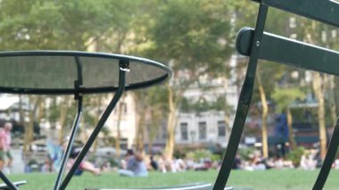 New York, Birleşik Devletler - 5 Eylül 2023: Manhattan şehir merkezi Bryant Park, 42 sokak ve 5. cadde köşesi. Amerika 'da NYC' nin simgesi. Yaz mevsiminde boş sandalye ve masa.