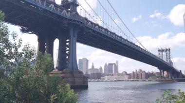 New York, ABD - 30 Ağustos 2023 Manhattan Köprüsü, Brooklyn Dumbo. Şehir merkezinde rıhtım manzarası, finansal bölge gökdelenleri gökdelenleri. East River köprüsünün altındaki Riverfront John sokak parkı