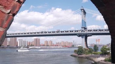 New York, ABD - 30 Ağustos 2023: Manhattan Köprüsü 'nden Brooklyn Dumbo' ya. Liman manzaralı, Time Out Market çatısı, East River suyu. Nehir kenarındaki konut binaları. Eski kırmızı tuğla kemer.