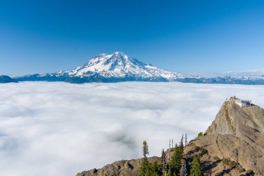 Washington 'daki bulutların üzerinde Rainier Dağı ve High Rock Gözcüsü 