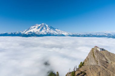 Washington 'daki bulutların üzerinde Rainier Dağı ve High Rock Gözcüsü 