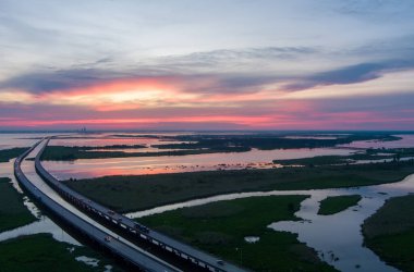 Mayıs 'ta Alabama Körfezi kıyısında gün batımında Jübile Parkway ve Mobil Körfezi' nin hava manzarası