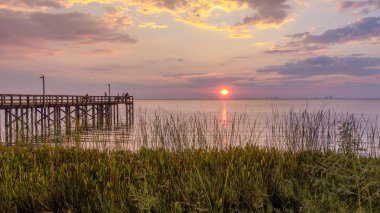 Bayfront Park pier at sunset on the Eastern shore of Mobile Bay in Daphne, Alabama clipart