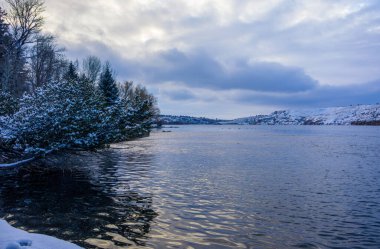 Aralıkta gün batımında Great Falls, Montana 'daki Giant Springs eyalet parkını kar kapladı.