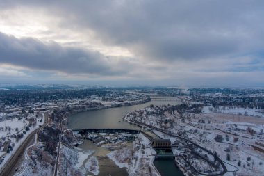 Drone view of a snow covered Great Falls, Montana at sunset in December clipart