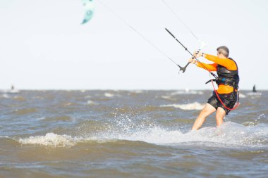 Buenos Aires, Arjantin 'deki Rio de la Plata Nehri' nde uçurtma sörfü yapan bir adam.