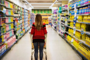 Süpermarkette alışveriş arabalı bir kadın.