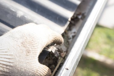 Bir adam iş küreleriyle olukları temizliyor. Evle ilgilenmek.