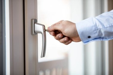 Gündüz vakti balkon kapısını kilitleyen bir elin yakınlaşması