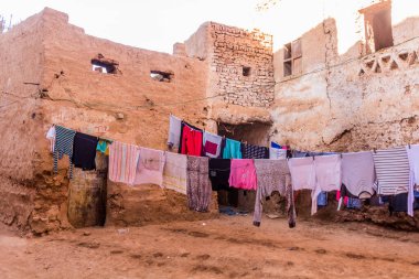 Dakhla vahasındaki Mut kasabasındaki eski çamur tuğlalı evler arasında çamaşır yıkama