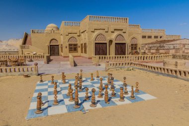 Terk edilmiş çamur tuğlası otel cadısı Mısır 'ın Dakhla vahasındaki Al Qasr köyünde bir satranç tahtası.