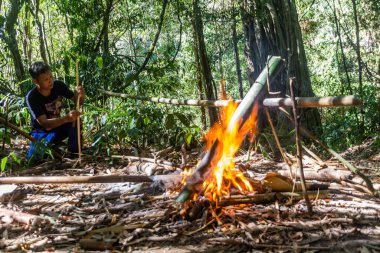 LUANG NAMTHA, LAOS - 18 Kasım 2019: Luang Namtha kasabası yakınlarındaki bir ormanda çorba hazırlayan yerel rehber