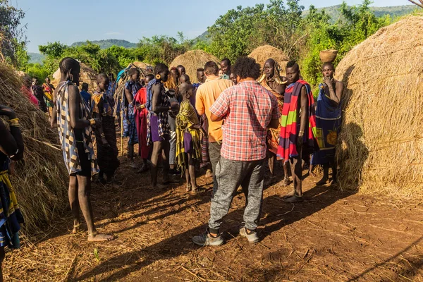 stock image OMO VALLEY, ETHIOPIA - FEBRUARY 6, 2020: Tourist visiting Mursi tribe village, Ethiopia