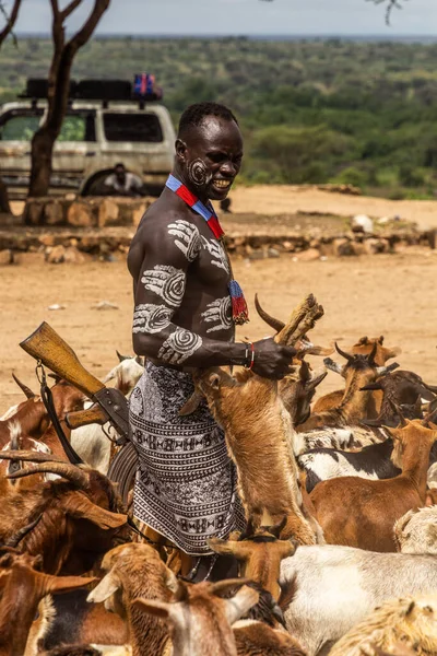 stock image KORCHO, ETHIOPIA - FEBRUARY 4, 2020: Karo tribal man with a rifle and goats in Korcho village, Ethiopia