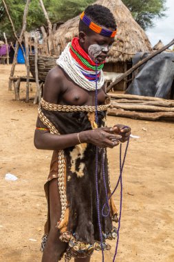 KORCHO, ETHIOPIA - 4 Şubat 2020: Karo kabile kızı, Etiyopya 'daki Korcho köyünde boncuk kolye yapıyor.
