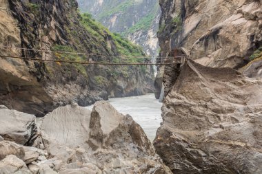 Yunnan 'ın Kaplan Sıçrayan Vadisi' ndeki Jinsha Nehri üzerinde asılı duran bir köprü.