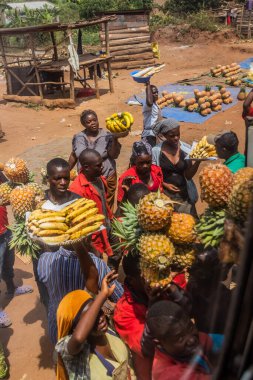UGANDA - 7 Mart 2020: Meyvelerini otobüs yolcularına satan satıcılar, Uganda