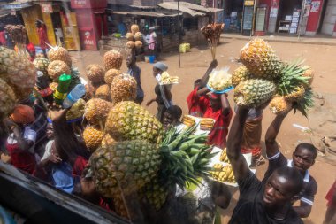 UGANDA - 7 Mart 2020: Meyvelerini otobüs yolcularına satan satıcılar, Uganda