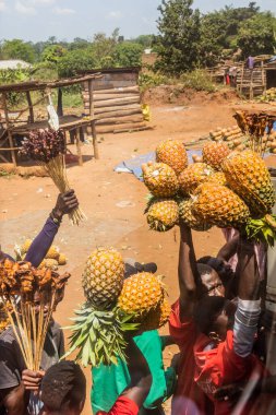 UGANDA - 7 Mart 2020: Ananas ve et satıcılarının yiyeceklerini otobüs yolcuları Uganda 'ya satışı