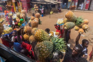 UGANDA - 7 Mart 2020: Meyvelerini otobüs yolcularına satan satıcılar, Uganda