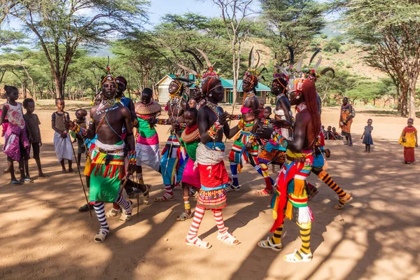 stock image SOUTH HORR, KENYA - FEBRUARY 12, 2020: Group of Samburu tribe young men and women dancing wearing colorful headpieces made of ostrich feathers after malecircumcision ceremony.