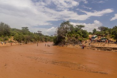 OMO VALLEY, ETHIOPIA - 4 Şubat 2020: insanlar Etiyopya 'nın Kizo Nehri' ni geçiyor