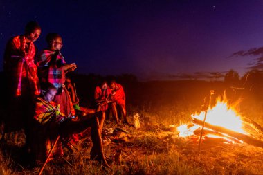 MASAI MARA, KENYA - 20 Şubat 2020: şenlik ateşiyle Masai erkekleri, Kenya