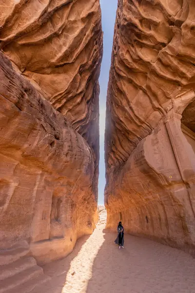 ALULA, SAUDI ARABIA - NOVEMBER 9, 2021: El Ula, Suudi Arabistan yakınlarındaki Hegra (Mada 'in Salih) sahasında Jabal Ithlib dağı, Siq boyunca dar geçitte yerel rehber