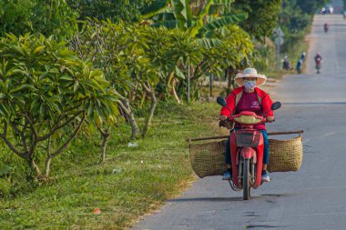 LUANG NAMTHA, LAOS 19 Kasım 2019: Luang Namtha kasabasında motorsikletli bir kadın