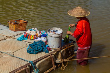 MUANG STK NEUA, LAOS - 25 Kasım 2019: Muang Ngoi Neua köyündeki Nam Ou nehrinde çamaşır yıkayan yerel kadın