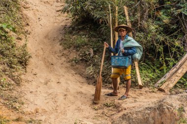 NAM OU, LAOS - 24 Kasım 2019: Laos 'un Luang Prabang ilindeki Nam Ou nehrinin yanında kürek çeken adam