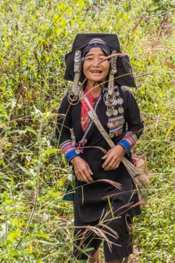 SAMARKISay, LAOS - 22 Kasım 2019: Laos 'un Phongsali ilinde Samarkisay köyü yakınlarında geleneksel kıyafetleriyle Akha etnik kökenli kadın