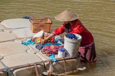 MUANG STK NEUA, LAOS - 25 Kasım 2019: Muang Ngoi Neua köyündeki Nam Ou nehrinde çamaşır yıkayan yerel kadın