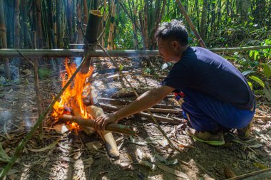 LUANG NAMTHA, LAOS - 18 Kasım 2019: Luang Namtha kasabası yakınlarındaki bir ormanda çorba hazırlayan yerel rehber