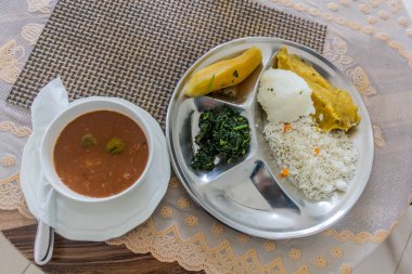 Lunch in Uganda - bean soup with matoke (mashed plantains), rice, posho (corn meal) and sukuma clipart