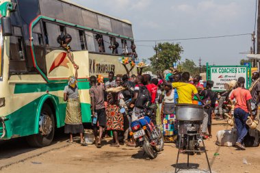 PAKWACH, UGANDA - 7 Mart 2020: Pakwach, Uganda 'daki otobüs yolcularına yiyecek satan satıcılar