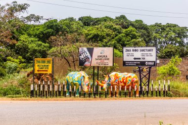 ZIWA, UGANDA - 9 Mart 2020 Ziwa Rhino Sığınağı yakınlarındaki işaretler ve gergedan heykelleri, Uganda