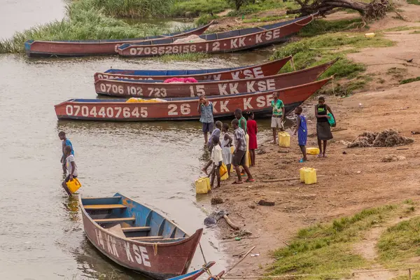 stock image KATUNGURU, UGANDA - MARCH 16, 2020: Children collect water from Kazinga Channel in Katunguru village, Uganda