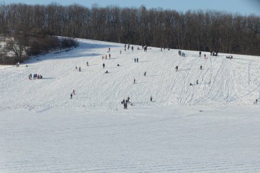 DLOUHONOVICE, CZEHIA - 13 Şubat 2021: İnsanlar Çek Cumhuriyeti 'nin Dlouhonovice yakınlarında karlı bir tepenin keyfini çıkarıyorlar