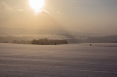 Çek Cumhuriyeti 'nin Orlicke boynuzlu dağlarında karla kaplı bir arazide yürüyen iki kişi.