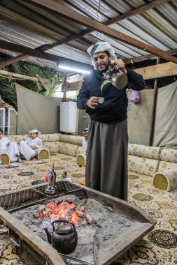 NAJRAN, SAUDI ARABIA - 27 Kasım 2021: Najran, Suudi Arabistan 'da Yam kabilesi üyesi kahve dolduruyor