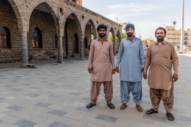 MEDINA, SAUDI ARABIA - NOVEMBER 12, 2021: Pakistani workers renovating the former train station of Hejaz railway in Medina, Saudi Arabia clipart