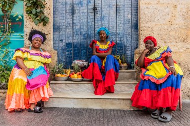 CARTAGENA DE INDIAS, COLOMBIA - 5 Mart 2023: Palenquera kostümlü kadınlar Kartagena 'nın merkezinde meyve satıyorlar.